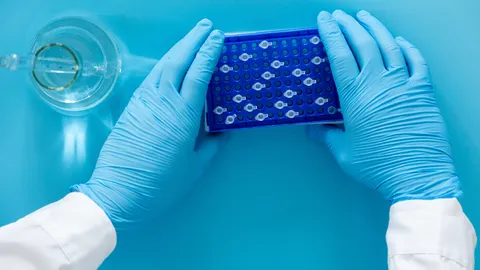 Laboratory technician handling LC sample vials to improve liquid chromatography workflow efficiency and performance.