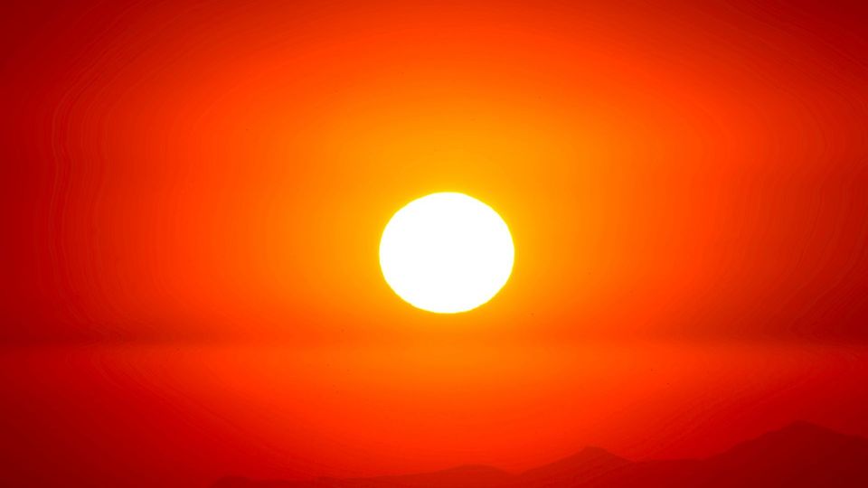 Bright sun over a hazy horizon at sunset.