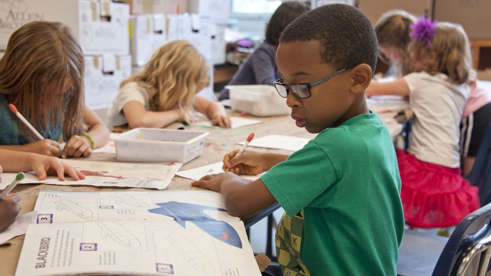 Children in school, focused on a learning activity.