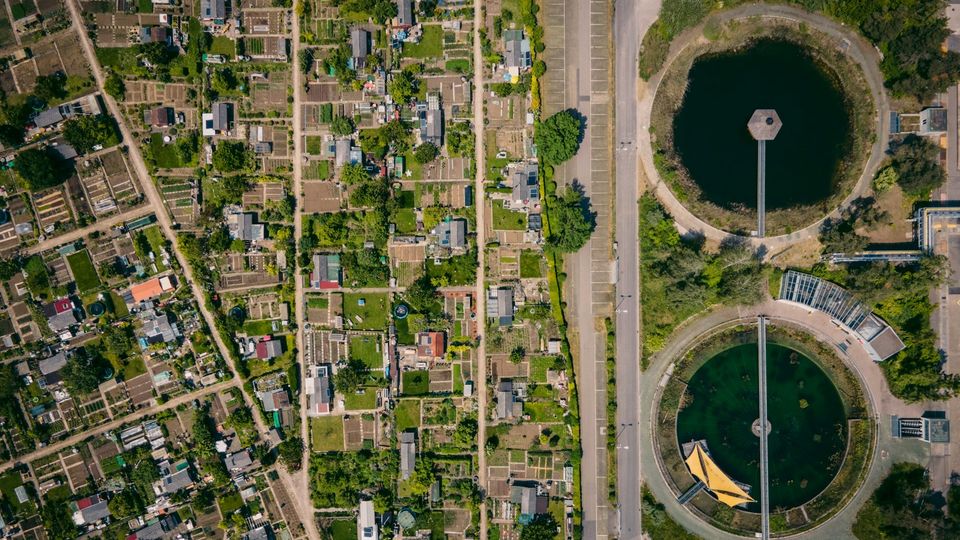 Aerial view of a sewage treatment plant beside residential gardens.