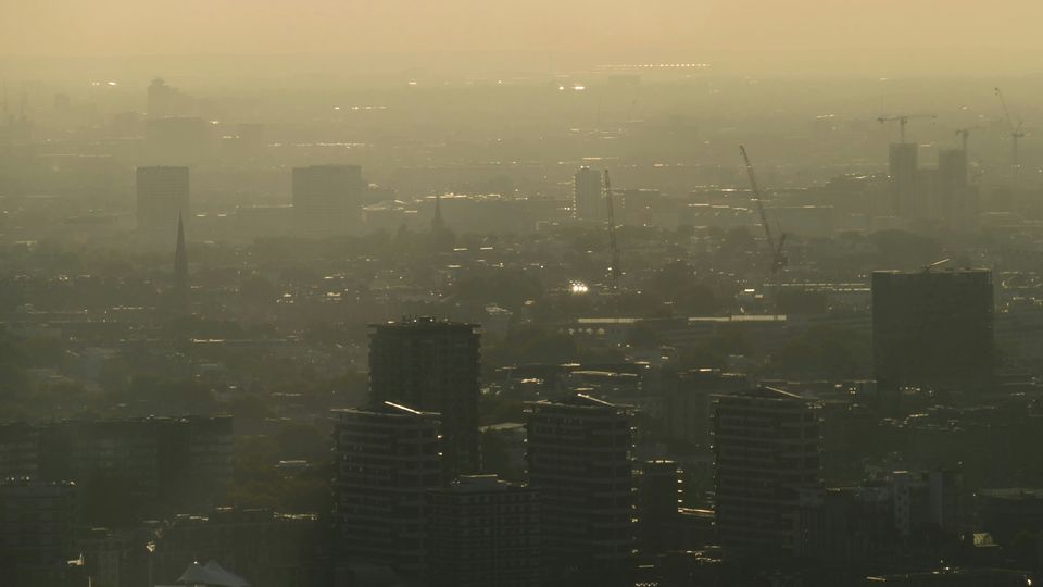 A city skyline, shrouded in light yellow smog.