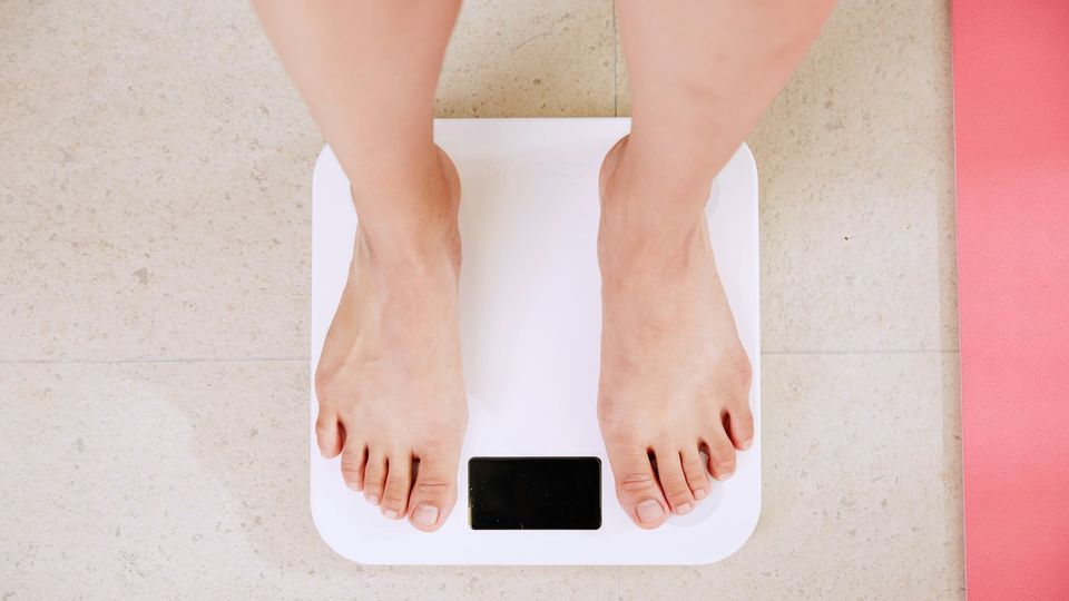 Bare feet standing on a digital bathroom scale.