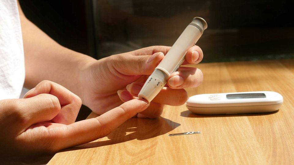 Close-up of a person using an insulin pen and glucose meter to check blood sugar.
