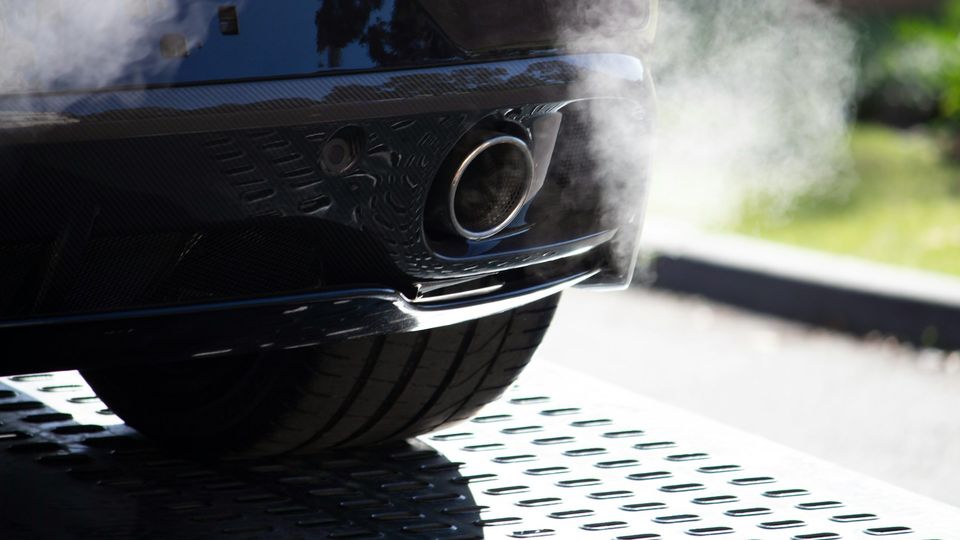 Car exhaust pipe emitting visible exhaust fumes.