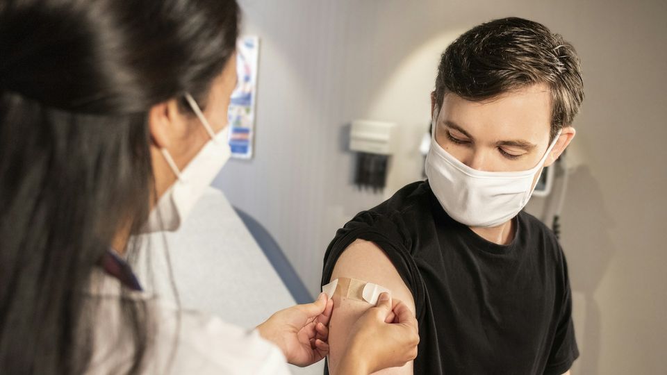 Young boy receiving a vaccination from a healthcare professional in a medical clinic.