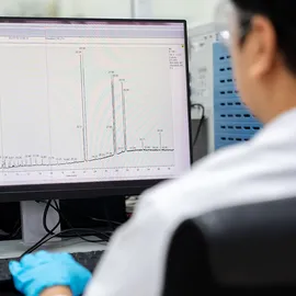 Laboratory scientist reviewing a gas chromatograph output to advance routine trace analysis by gas chromatography.