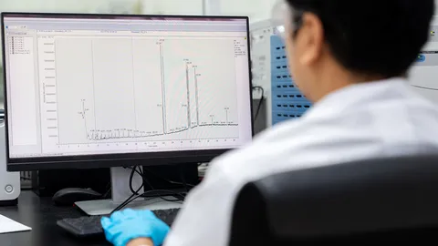 Laboratory scientist reviewing a gas chromatograph output to advance routine trace analysis by gas chromatography.
