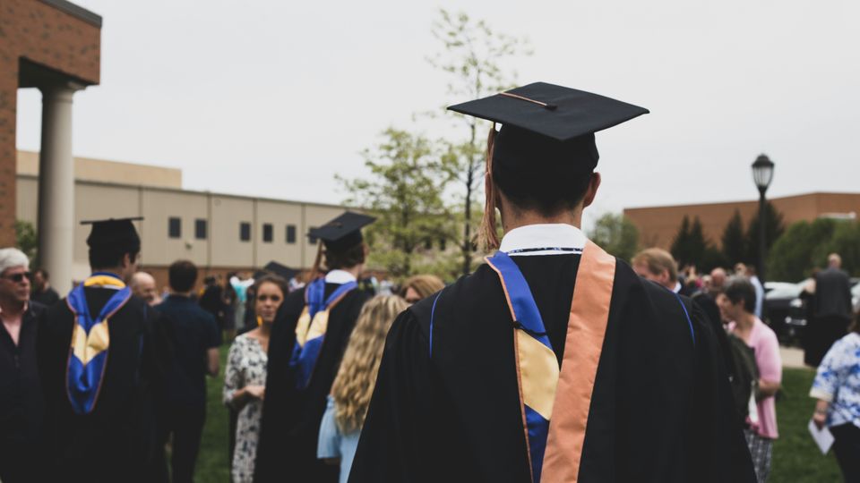 Graduates wearing caps and gowns on a college graduation day.