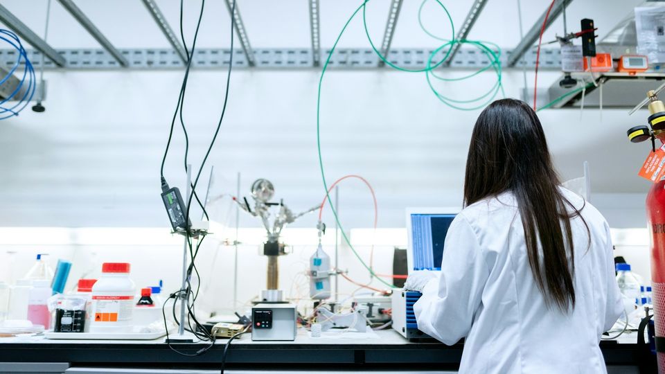 Researcher working at a laboratory bench with scientific equipment and instruments for biomedical research.