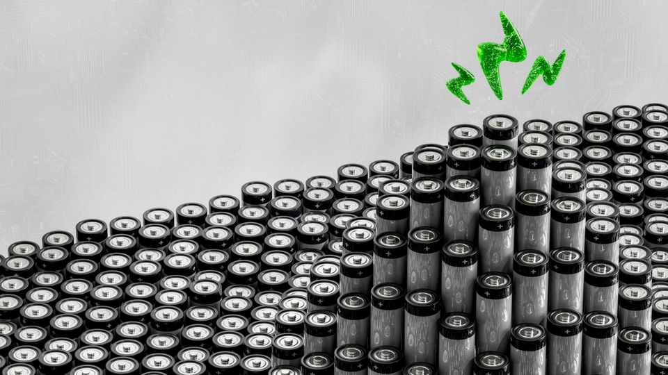 Stacks of cylindrical batteries with a green energy symbol.