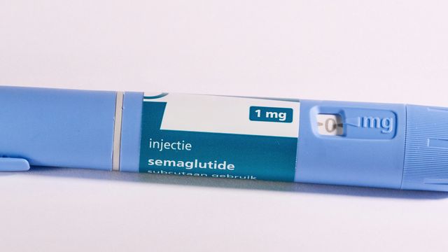 Close-up of a GLP-1 injection pen (semaglutide) on a white surface. 