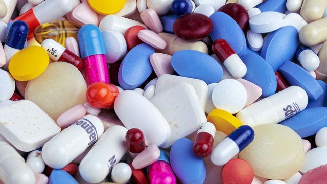 A pile of various pharmaceutical pills, tablets, and capsules. 