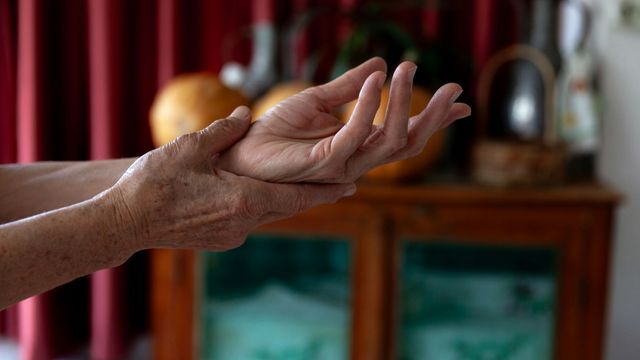 A person holding their hands together at the wrist. 