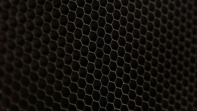 Hexagonal woven surface with a dark, textured honeycomb pattern. 