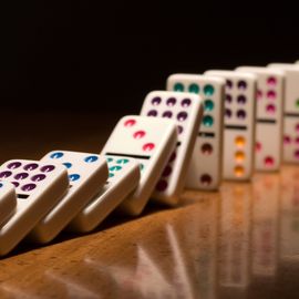 Dominoes falling illustrate the data noncompliance domino effect. 