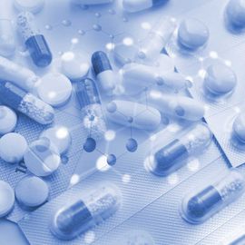 Assorted tablets and capsules in blister packs with molecular graphics, representing drug repurposing research. 