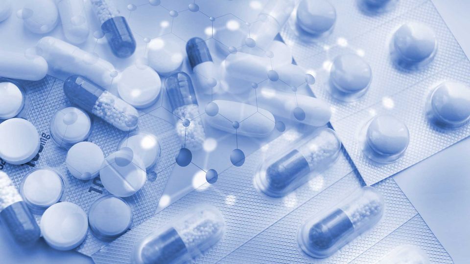 Assorted tablets and capsules in blister packs with molecular graphics, representing drug repurposing research.