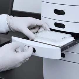 White-gloved hands handling a microplate for assessing plasmid topology and key QC parameters.