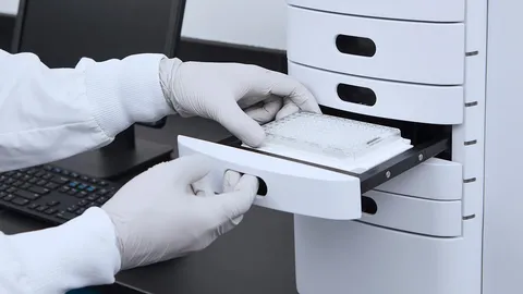 White-gloved hands handling a microplate for assessing plasmid topology and key QC parameters.