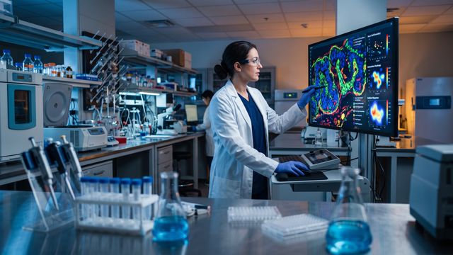 AI-generated image of a researcher viewing spatial infection maps on a fluorescence microscopy screen in a research lab. 