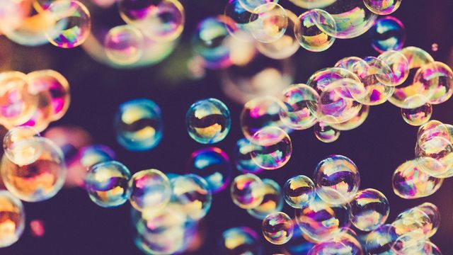 Colorful soap bubbles floating against a dark background. 