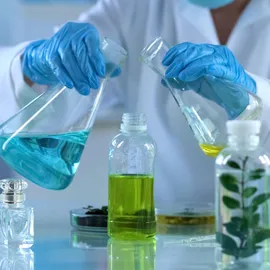 Scientist handling chemical flasks for sustainable SVOC analysis and automated extraction.
