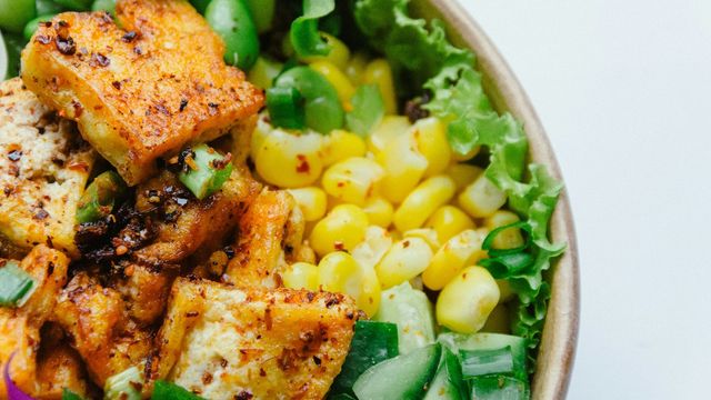 Fresh vegetable bowl with seasoned tofu and colorful vegetables. 