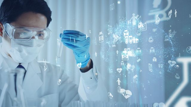 Scientist holding a test tube surrounded by a hologram of scientific and medical icons. 