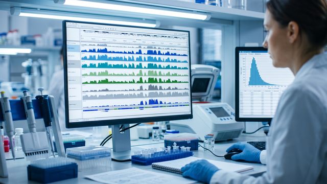 AI-generated image of a researcher examining sequencing coverage visualizations on a laboratory workstation monitor. 