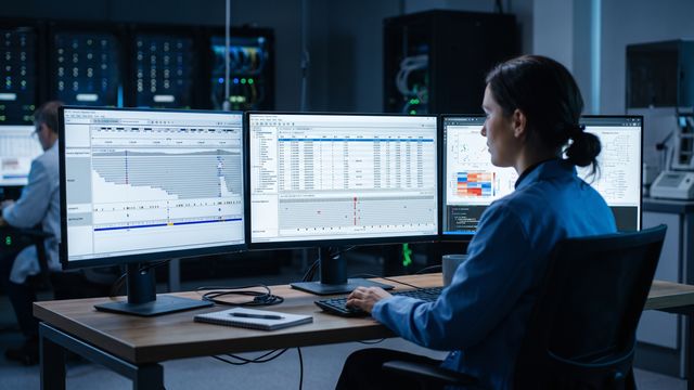 AI-generated image of a bioinformatics laboratory with a researcher analyzing variant call data on multiple large monitors. 
