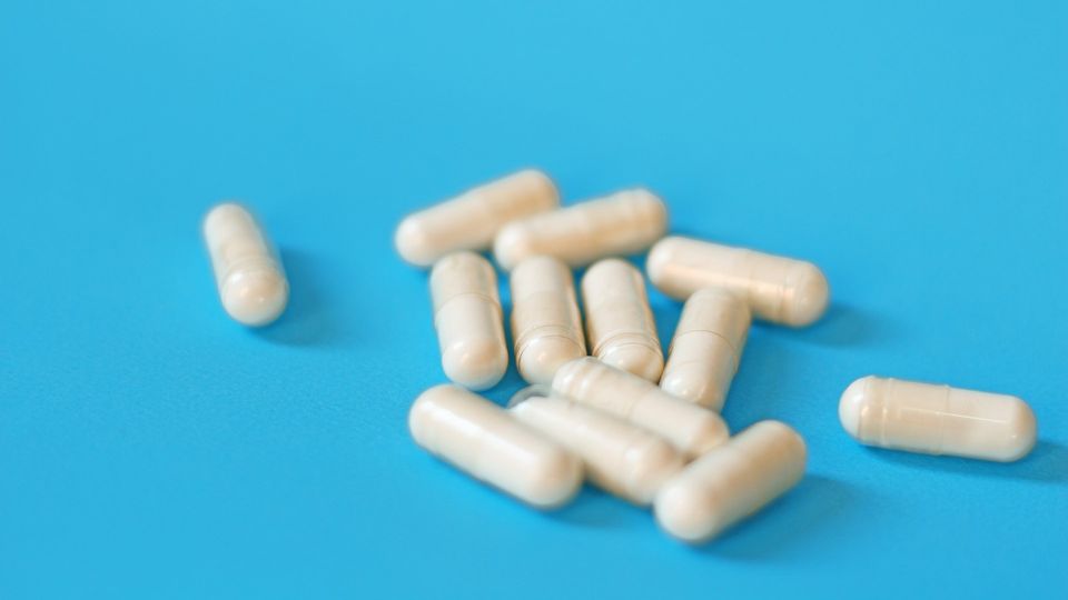White capsules scattered on a bright blue surface.