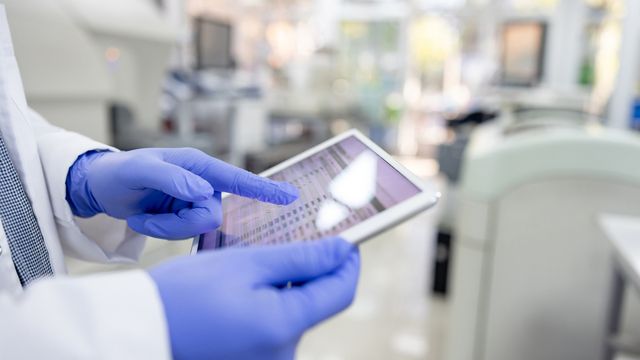 A researcher using a tablet in a laboratory environment. 