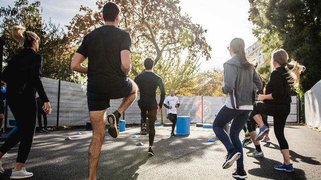 A group of men and women exercising outside. 