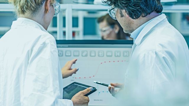 Researchers using digital tools to optimize bioprocessing efficiency and yield. 