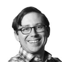 A headshot of a man wearing a shirt and glasses.