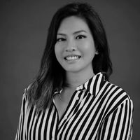 Black-and-white headshot of a smiling woman wearing a striped shirt against a plain background.