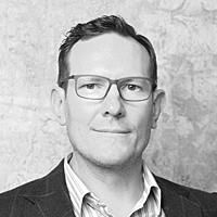 A greyscale headshot of Johnathan Raineau