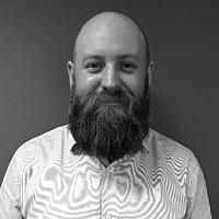 A greyscale headshot of Aidan Harrison