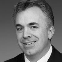 A black and white photograph of Dr. Ewing, smiling at the camera.