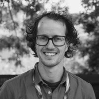 A black and white image of Pickering, smiling at the camera.