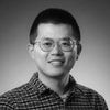 A black and white image of Ding, smiling at the camera.