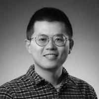A black and white image of Ding, smiling at the camera.