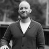 Smiling man in casual blazer for professional headshot portrait.