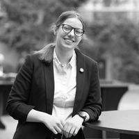 Smiling woman in glasses and blazer for professional headshot portrait.