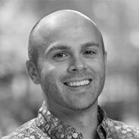 A grayscale image of Dr. Caleb Lareau, smiling at the camera.