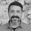 Scientist headshot in black and white, with short hair, a beard and collared shirt.